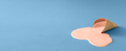 melted ice cream cone on blue background